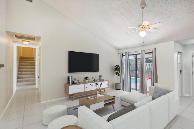 tiled living room featuring a textured ceiling, vaulted ceiling, and ceiling fan