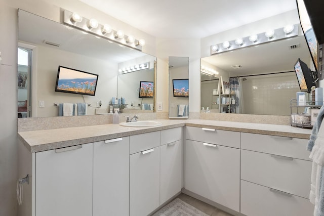 bathroom with a shower with shower curtain, vanity, and tile patterned flooring