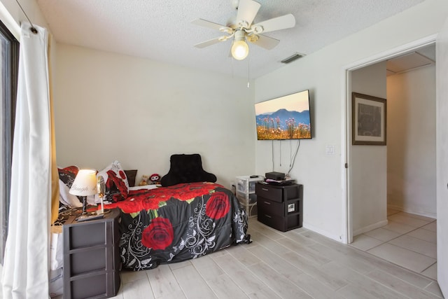 bedroom featuring ceiling fan and a textured ceiling