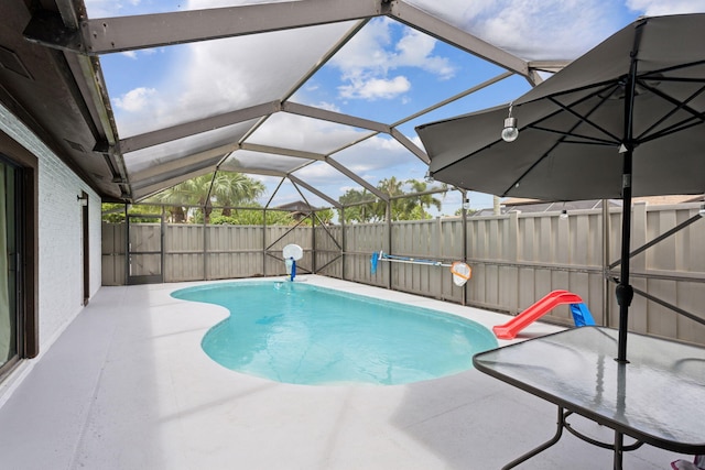 view of swimming pool with glass enclosure and a patio area