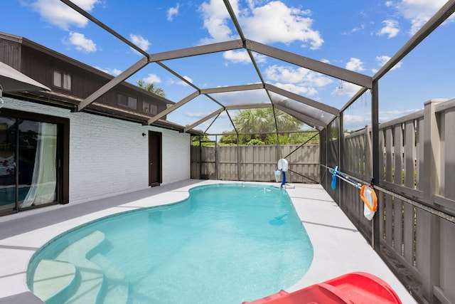 view of swimming pool featuring glass enclosure