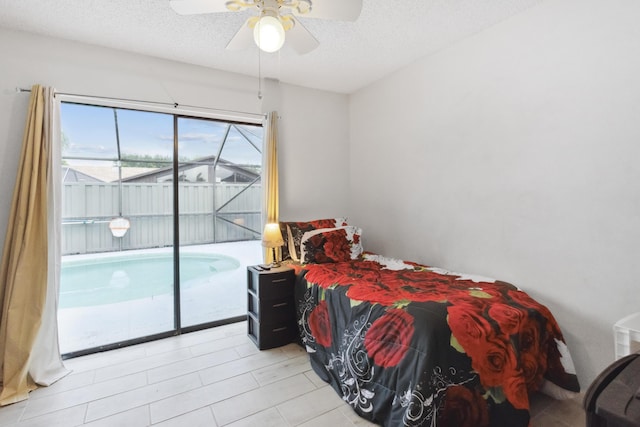 bedroom with access to exterior, a textured ceiling, and ceiling fan