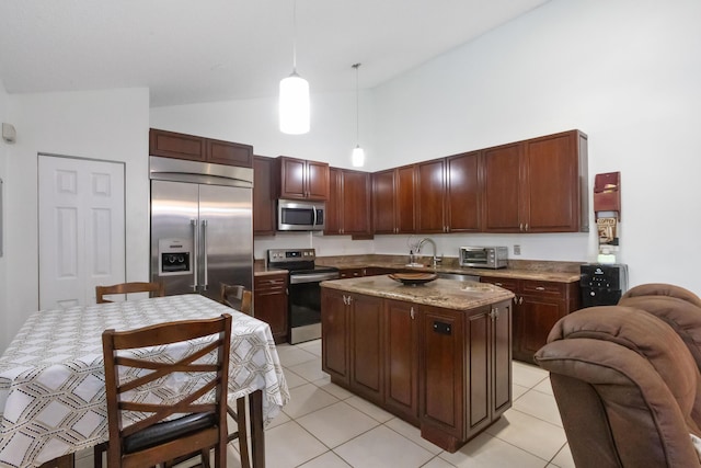 kitchen featuring appliances with stainless steel finishes, light tile patterned floors, pendant lighting, high vaulted ceiling, and a center island