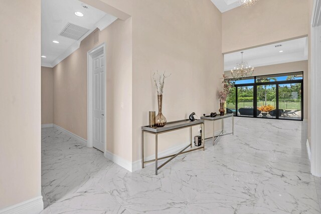 corridor with light tile patterned floors and a notable chandelier