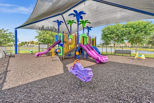 community playground with a water view and fence