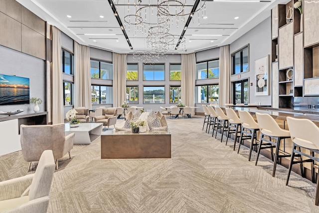 interior space featuring recessed lighting, light carpet, a towering ceiling, and an inviting chandelier