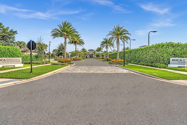 view of road featuring curbs, street lighting, traffic signs, and sidewalks