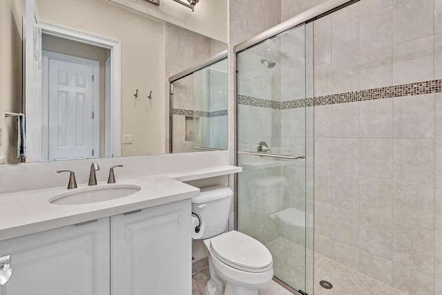 bathroom featuring a stall shower, vanity, and toilet