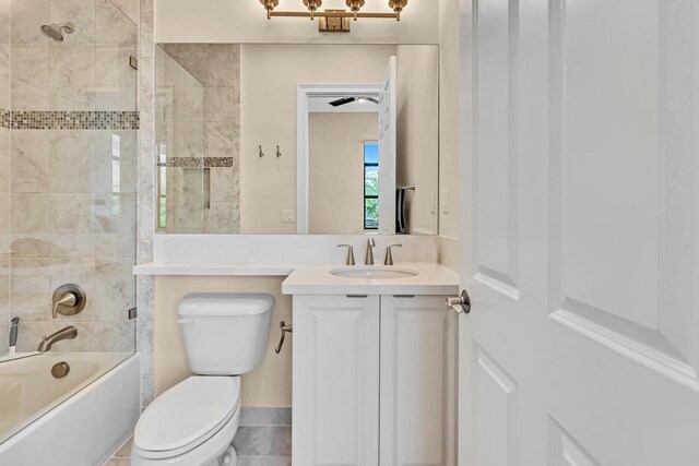 full bathroom featuring tile patterned flooring, toilet, tiled shower / bath combo, and vanity