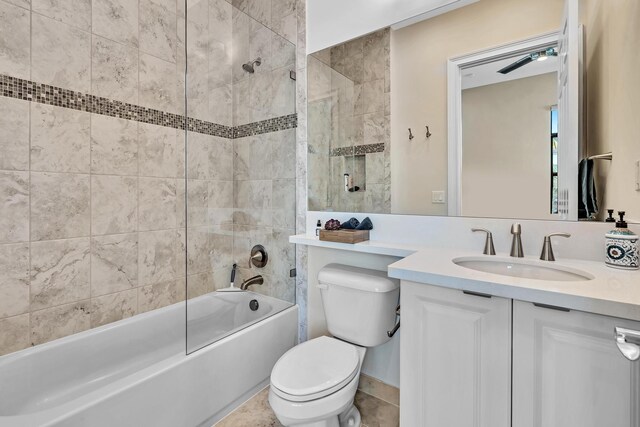 full bathroom with tile patterned flooring, toilet, tiled shower / bath combo, ceiling fan, and vanity