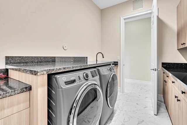 laundry room with washing machine and dryer and light tile patterned floors