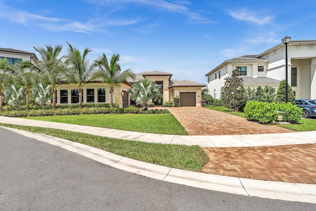 mediterranean / spanish home featuring a garage and a front yard