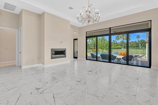 unfurnished living room with a chandelier and light tile patterned flooring