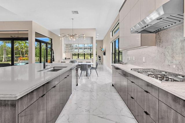 kitchen with modern cabinets, marble finish floor, a sink, and extractor fan