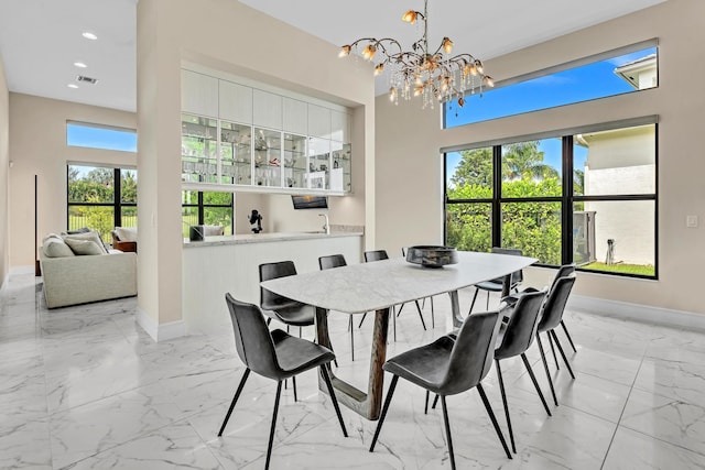 dining area with an inviting chandelier, a healthy amount of sunlight, and light tile patterned floors