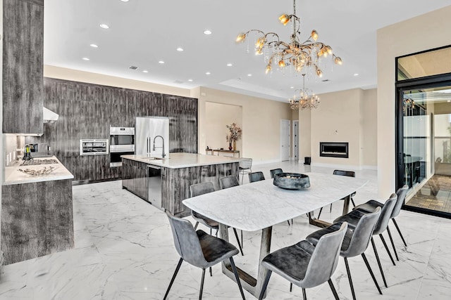 dining area featuring a fireplace, light tile patterned floors, and a notable chandelier