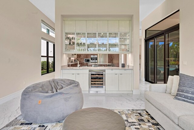 bar with light tile patterned floors, a healthy amount of sunlight, wine cooler, and sink