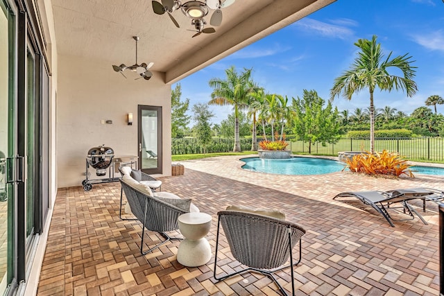 view of pool featuring pool water feature, ceiling fan, and a patio