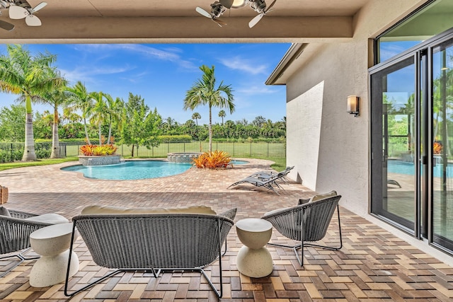 view of pool featuring an in ground hot tub, fence, a ceiling fan, a fenced in pool, and a patio area