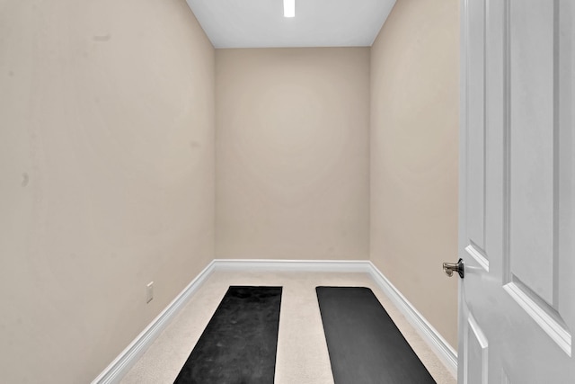 interior space featuring light carpet and baseboards