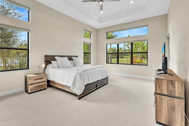 carpeted bedroom with a high ceiling, baseboards, a raised ceiling, and recessed lighting