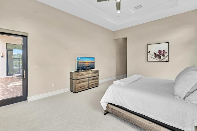 carpeted bedroom with visible vents, baseboards, ceiling fan, and a tray ceiling