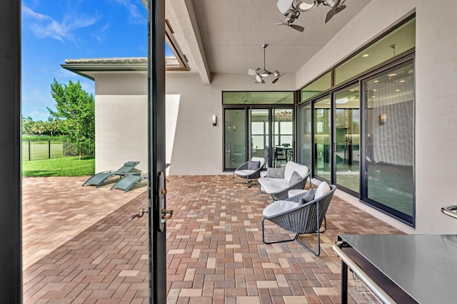 view of patio / terrace with fence and a ceiling fan