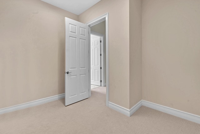 empty room with light carpet and baseboards