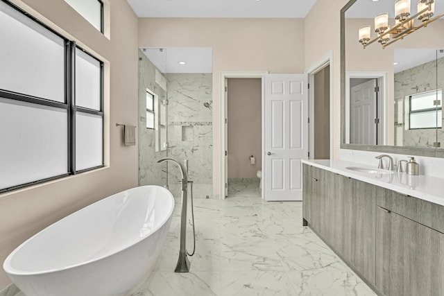 bathroom featuring a marble finish shower, toilet, marble finish floor, a freestanding bath, and vanity