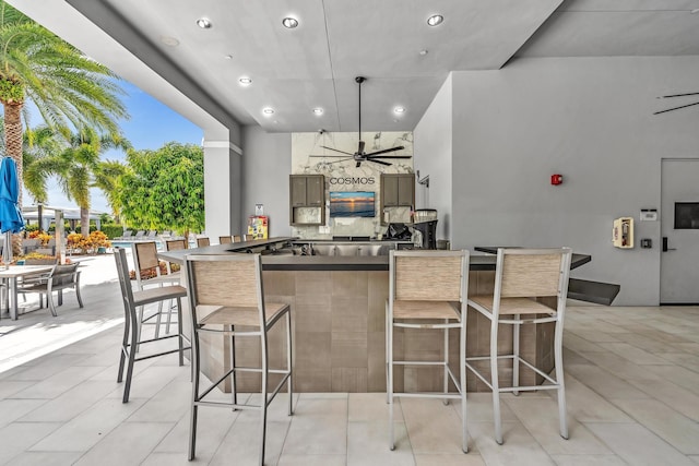 kitchen featuring a breakfast bar area, a spacious island, dark countertops, recessed lighting, and ceiling fan