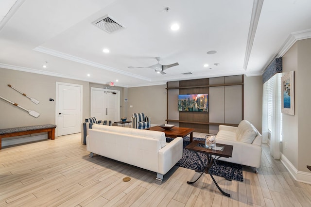 living room with a raised ceiling, ceiling fan, and ornamental molding