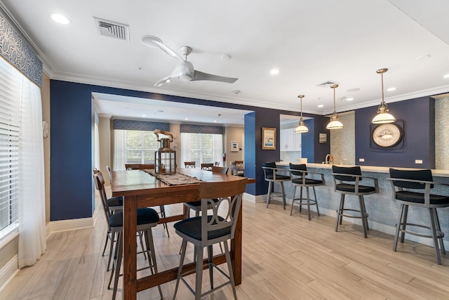 dining space featuring ceiling fan, light hardwood / wood-style floors, and ornamental molding