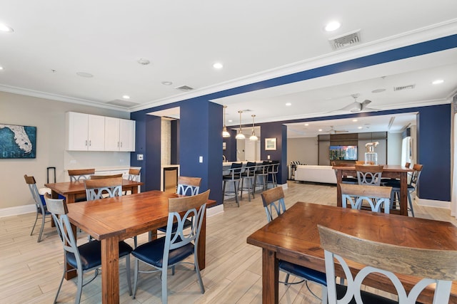 dining space with ceiling fan, light hardwood / wood-style floors, and ornamental molding