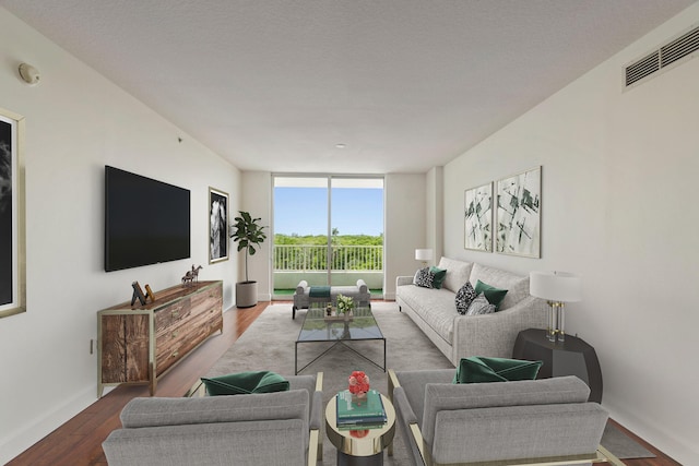 living room featuring wood-type flooring, a textured ceiling, and floor to ceiling windows