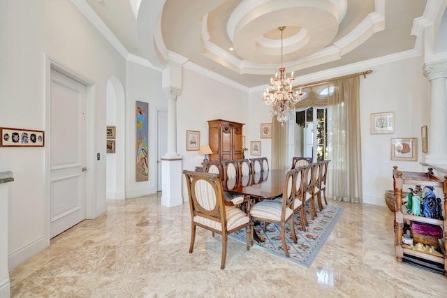 dining space with a chandelier, a raised ceiling, crown molding, and decorative columns