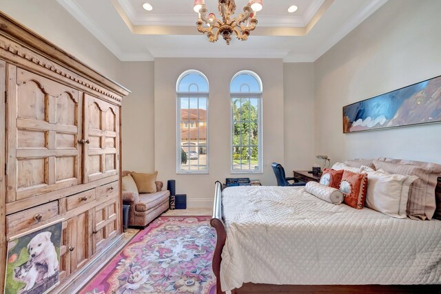 bedroom with ornamental molding, a tray ceiling, and a chandelier