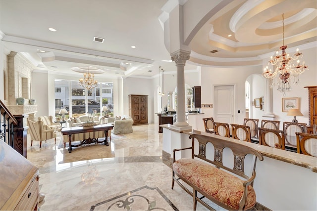 living room with a high end fireplace, a tray ceiling, plenty of natural light, and ornamental molding