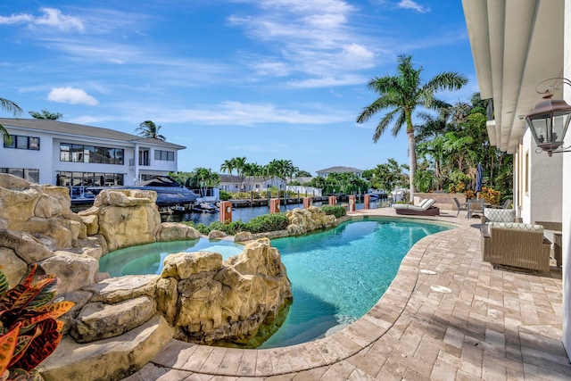 view of swimming pool featuring outdoor lounge area, a water view, an in ground hot tub, and a patio