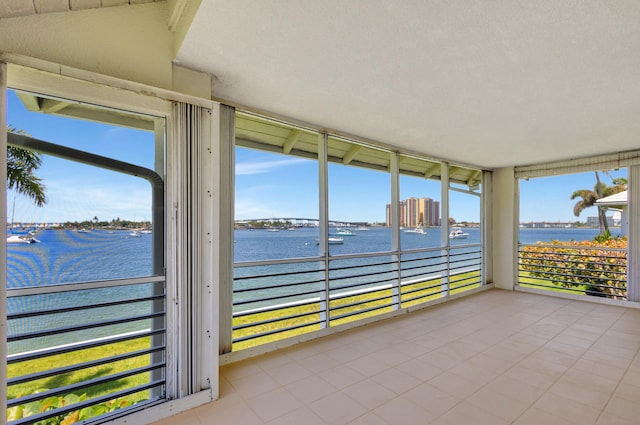 unfurnished sunroom with a water view