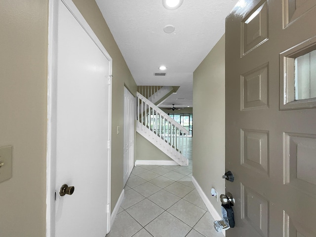 entryway with ceiling fan and light tile patterned flooring