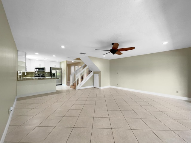 unfurnished living room with ceiling fan and light tile patterned flooring