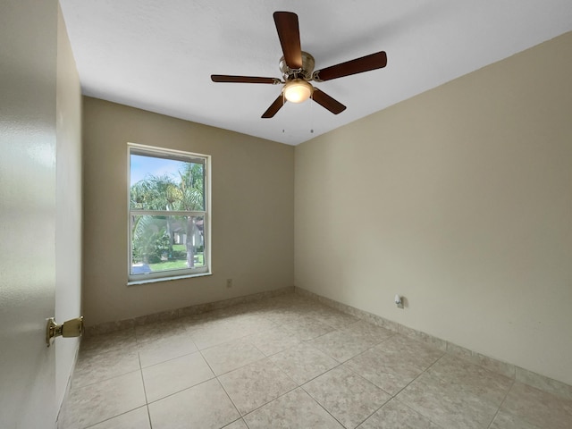 tiled spare room with ceiling fan