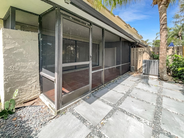 view of property exterior with a sunroom and central air condition unit