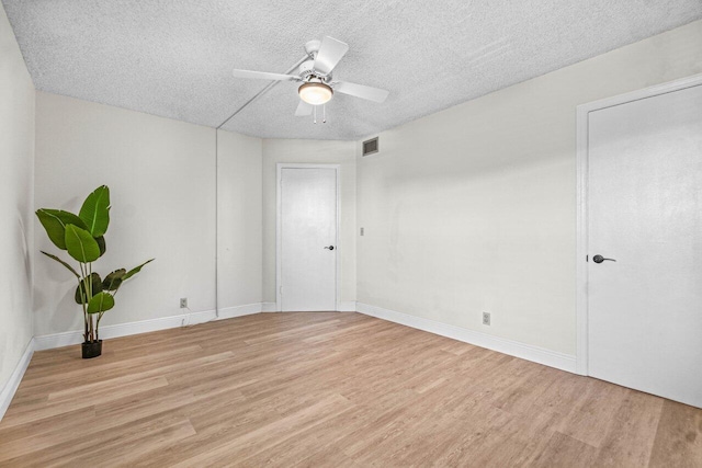 unfurnished room with ceiling fan, a textured ceiling, and light wood-type flooring