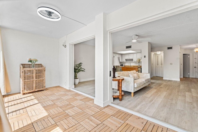 interior space with ceiling fan and a textured ceiling