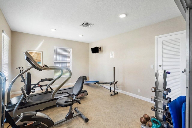 exercise area featuring a healthy amount of sunlight and a textured ceiling