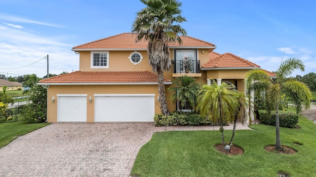 mediterranean / spanish house featuring a garage, a balcony, and a front lawn