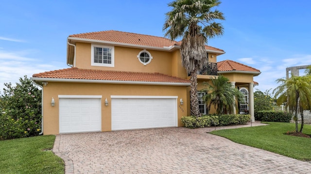 mediterranean / spanish home featuring a garage and a front lawn