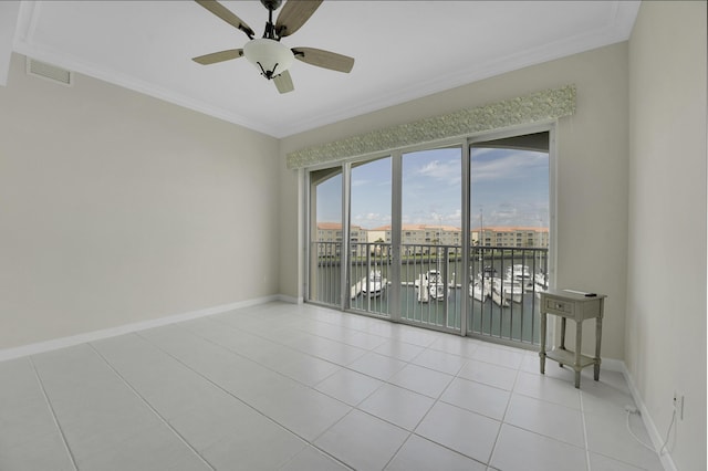 spare room featuring light tile patterned floors, ceiling fan, baseboards, ornamental molding, and visible vents