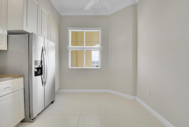 kitchen with white cabinetry, stainless steel refrigerator with ice dispenser, baseboards, and ornamental molding